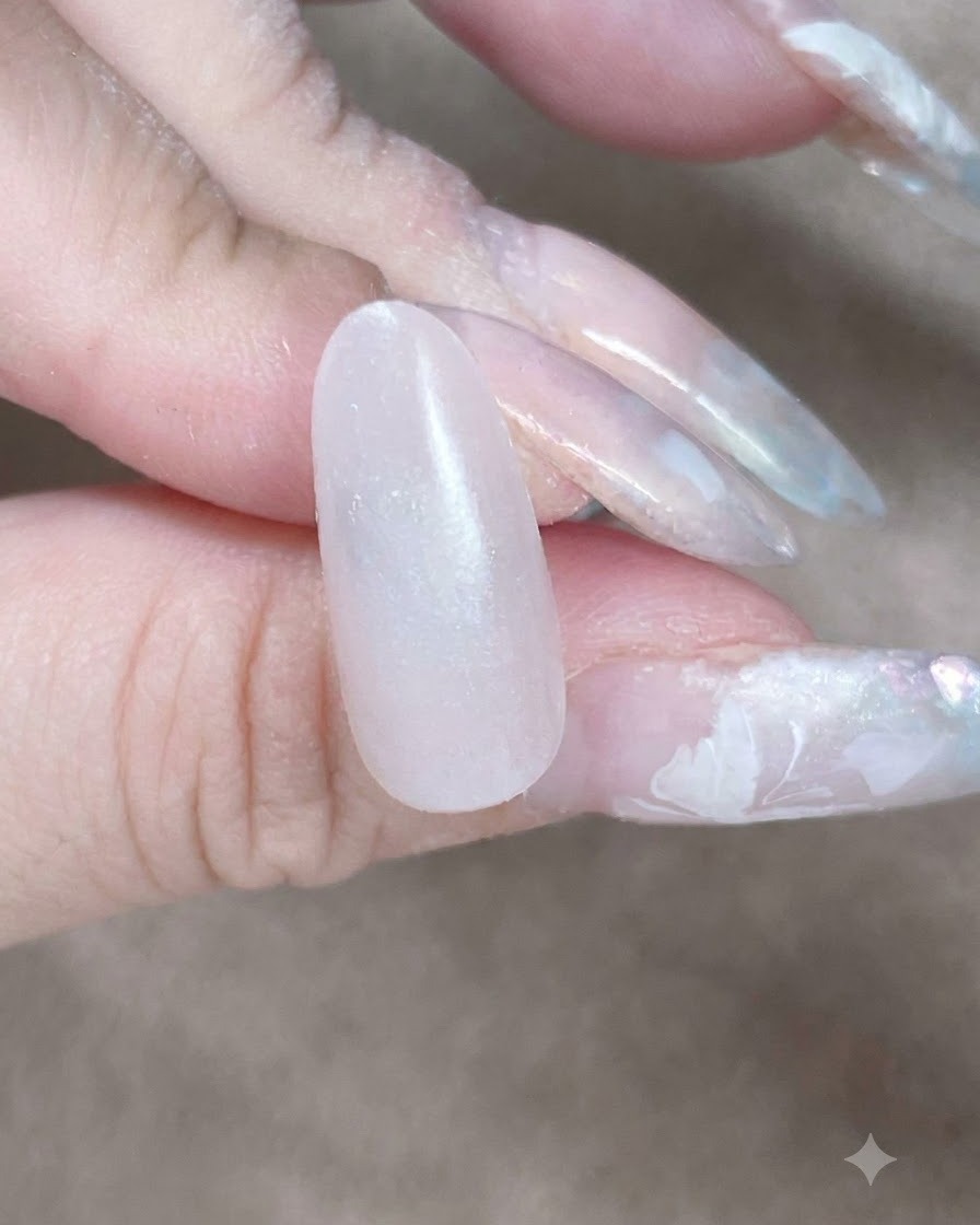 메이크업 스펀지가 젤 베이스 레이어를 블렌딩하기 위해 큐티클과 사이드월을 따라 톡톡 두드리는 클로즈업 뷰.