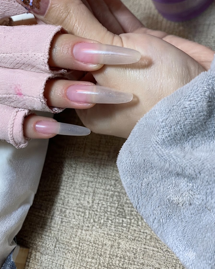 자유단 부위에 누드 젤을 두 번째 레이어로 조심스럽게 두드려 바르는 클로즈업 뷰.