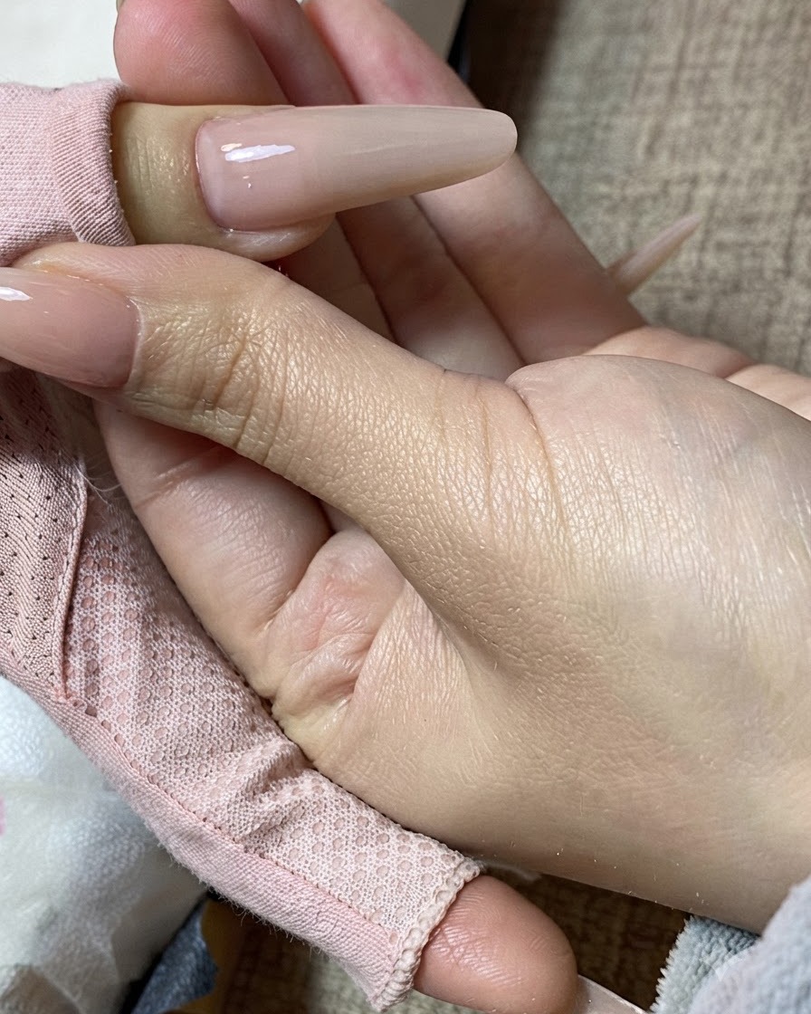 완성된 밀크티 매니큐어 네일을 손에 쥔 모습의 클로즈업 뷰.