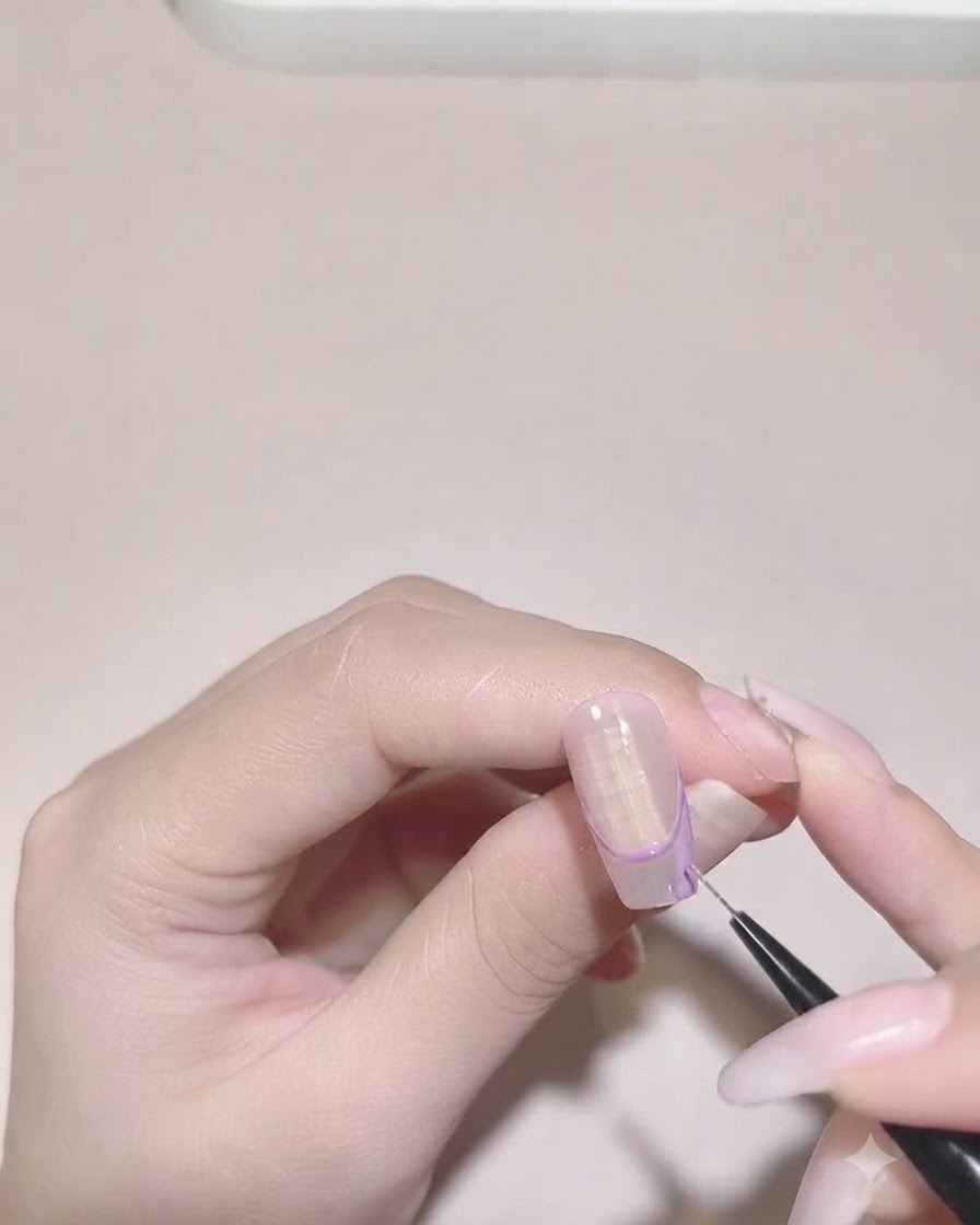 네일의 불규칙한 프렌치 팁 경계 안쪽의 보라색 색상을 채우는 디테일 브러시.