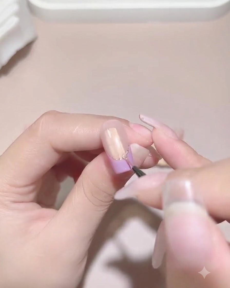 매니큐어된 네일의 부착된 진주와 라인스톤의 밑둥 주변에 실링 젤을 조심스럽게 바르는 고운 디테일 브러시.