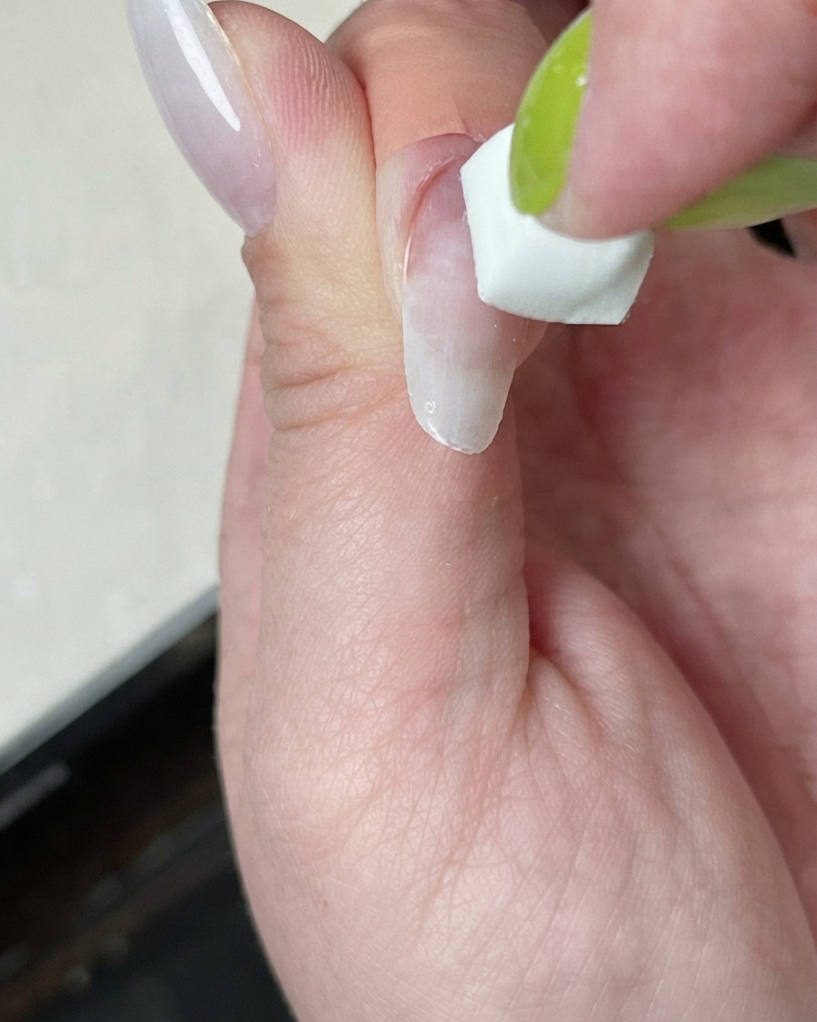 하얀 불빛이 나오는 미니 큐어링 램프 아래에서 네일이 경화되는 모습.