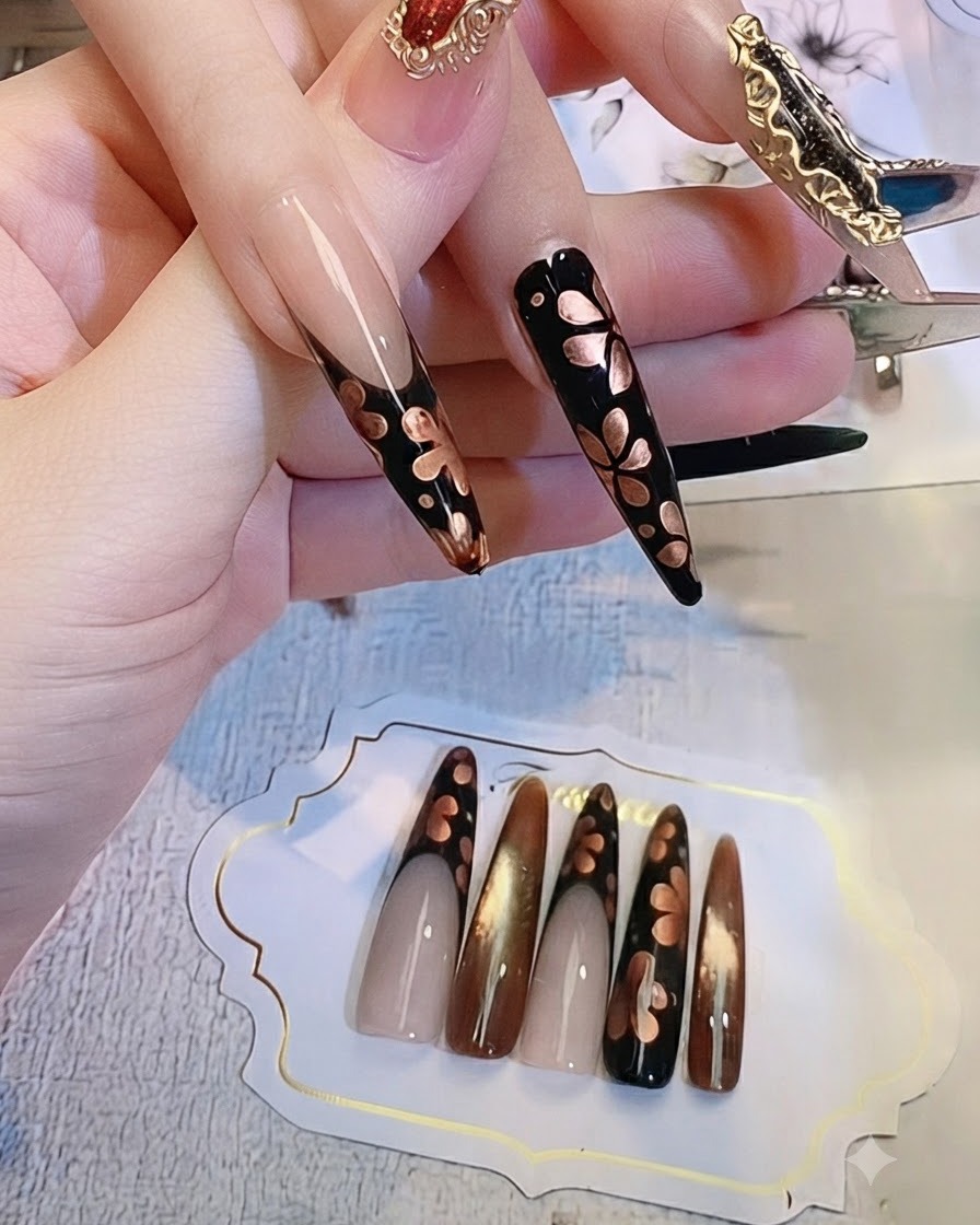메탈릭 블루밍 디테일이 들어간 어두운 네일 손을 클로즈업하여 표면이 건조되는 과정을 보여줌.