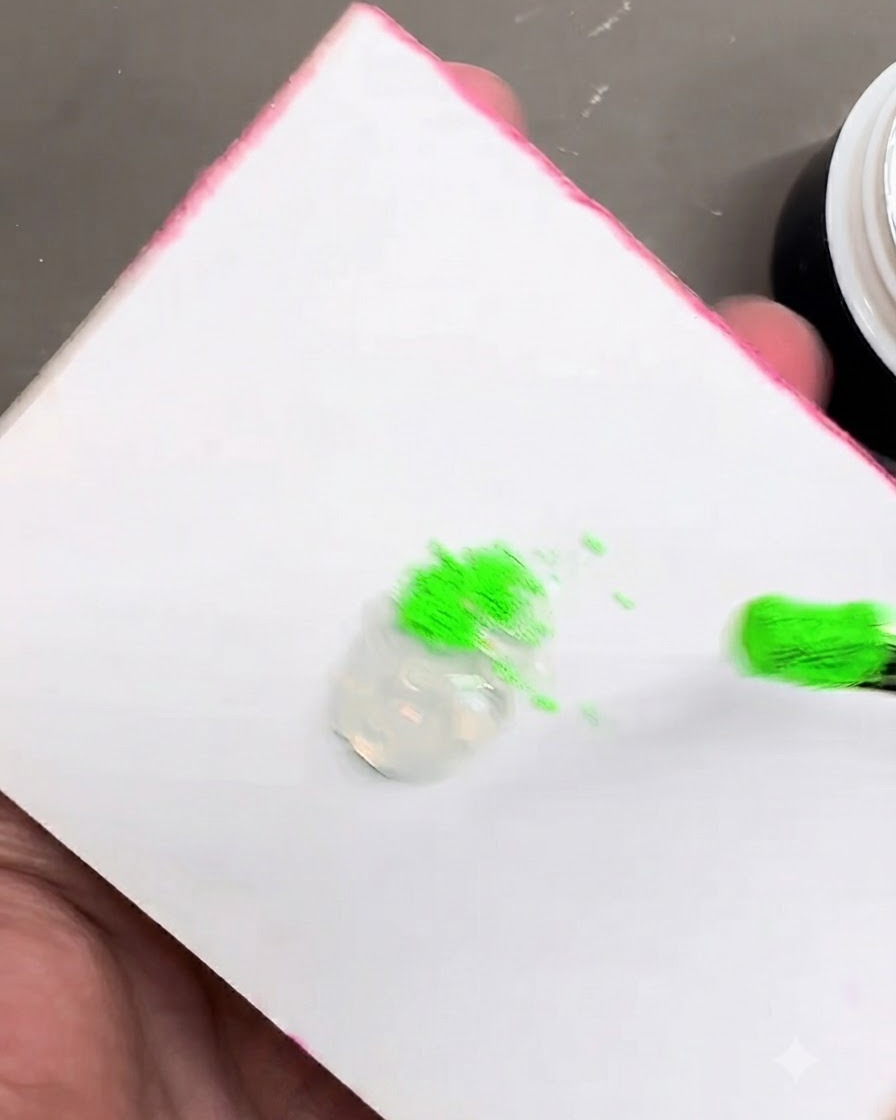 투명한 스타일링 젤 덩어리 옆에 놓인 밝은 녹색 피그먼트 파우더의 모습.