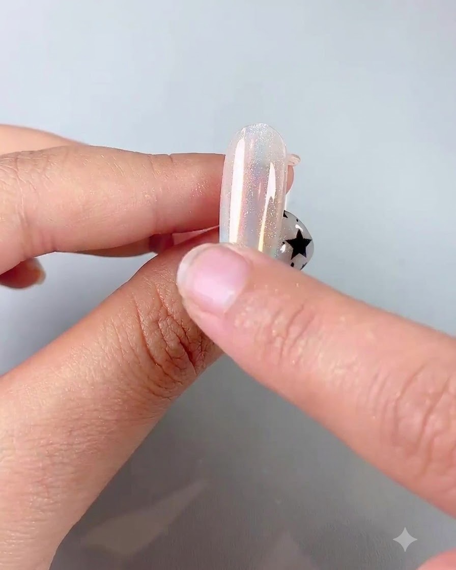 실리콘 스폰지 어플리케이터를 이용해 영롱한 크롬 파우더를 광택 있는 손톱에 문지르는 모습.