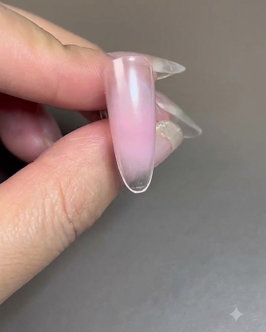 UV/LED 네일 램프 아래에서 블러시 젤이 경화되고 있는 네일.