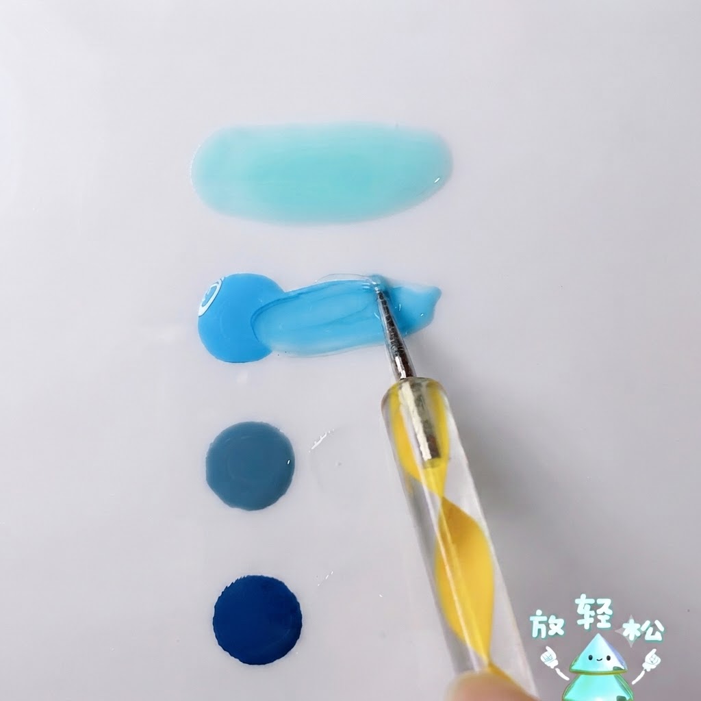 화이트 팔레트 표면에서 밝은 스카이 블루 젤을 투명젤과 함께 섞고 있는 도팅 펜.