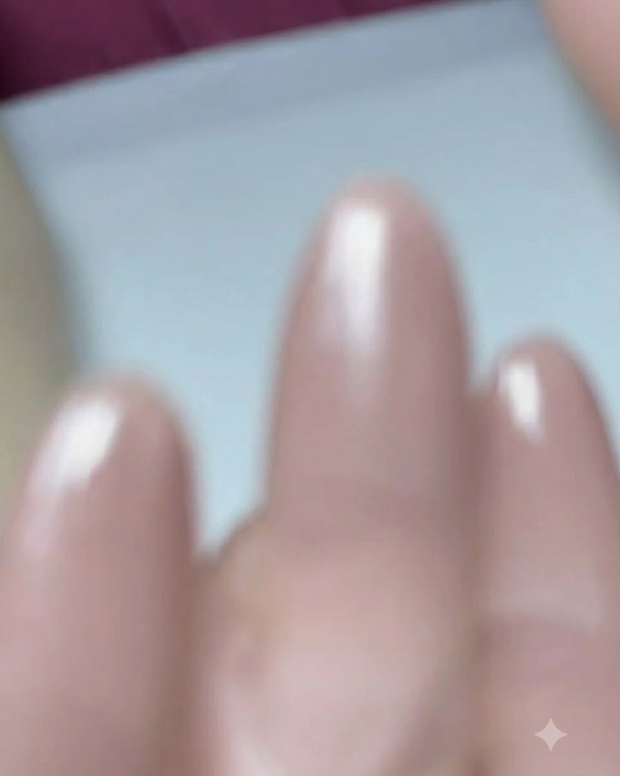 네일 브러시가 미리 정돈된 아몬드 모양 손톱 위에 베이스 코트 젤을 바르고 있는 클로즈업 샷.