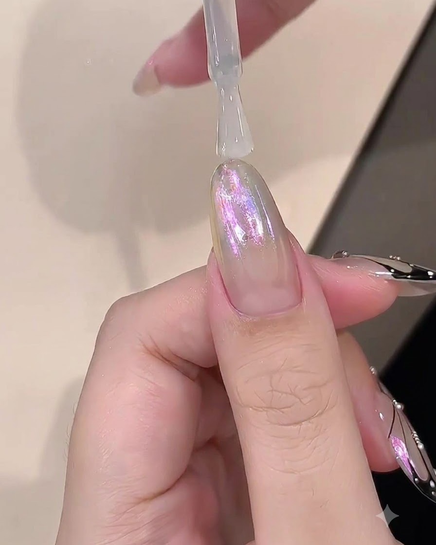 크롬 마감된 네일 위에 빌더 젤의 투명한 레이어를 붓으로 바르는 모습.