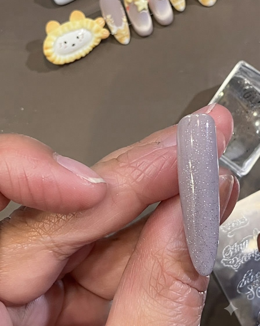 작은 클린업 브러시로 매니큐어 처리된 네일 측면 피부 주변에 묻은 어두운 스탬핑 폴리시를 닦아내는 모습.