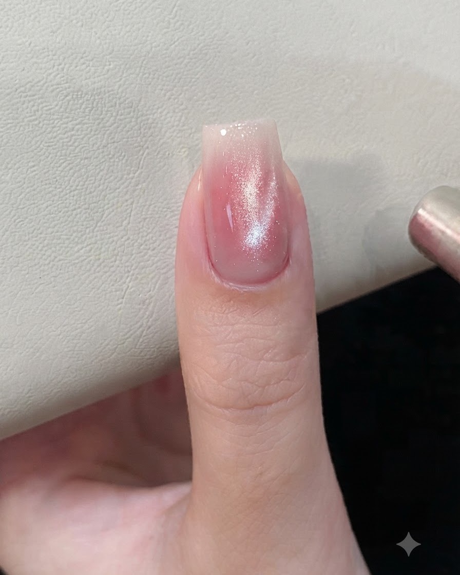 핑크와 실버 캣아이 젤 네일 가까이에 자석 도구를 대어 자성 입자를 모양 잡는 모습.