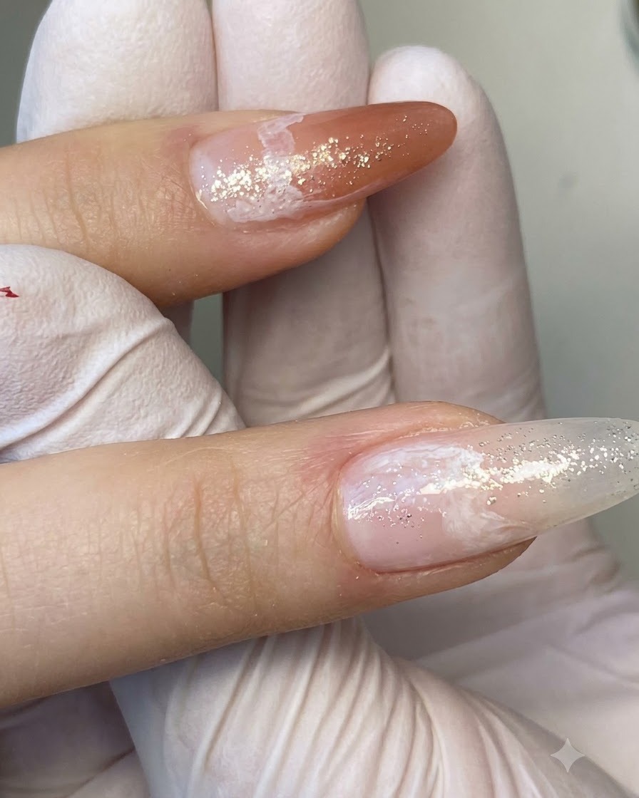 파인 라이너 브러시가 그라데이션 네일에 섬세한 화이트 마블 베인 패턴을 그리는 근접 샷.