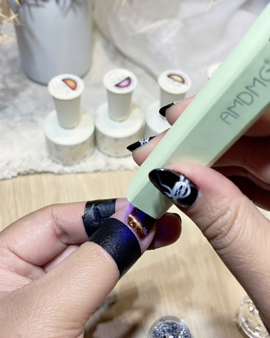완성된 별 장식 네일을 큐어링하는 미니 그린 UV/LED 램프.